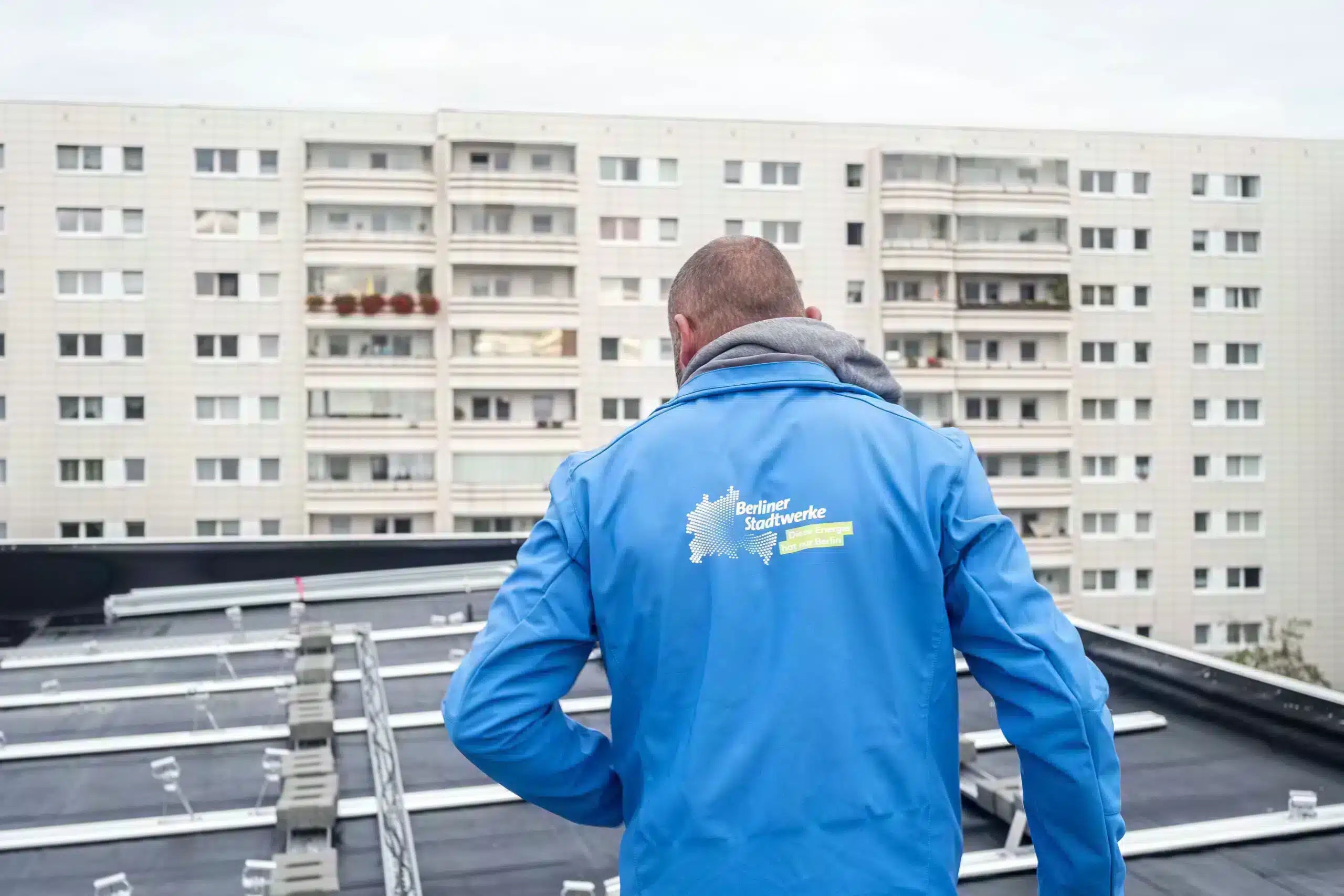 Mitarbeiter der Berliner Stadtwerke von hinten bei der Montage der Mieterstrom-Anlage im Mühlengrund