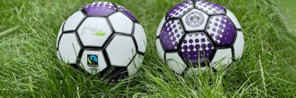 Zwei Fußbälle auf dem Rasen mit Logos der Berliner Stadtwerke und vom Fußballclub Tennis Borussia Berlin