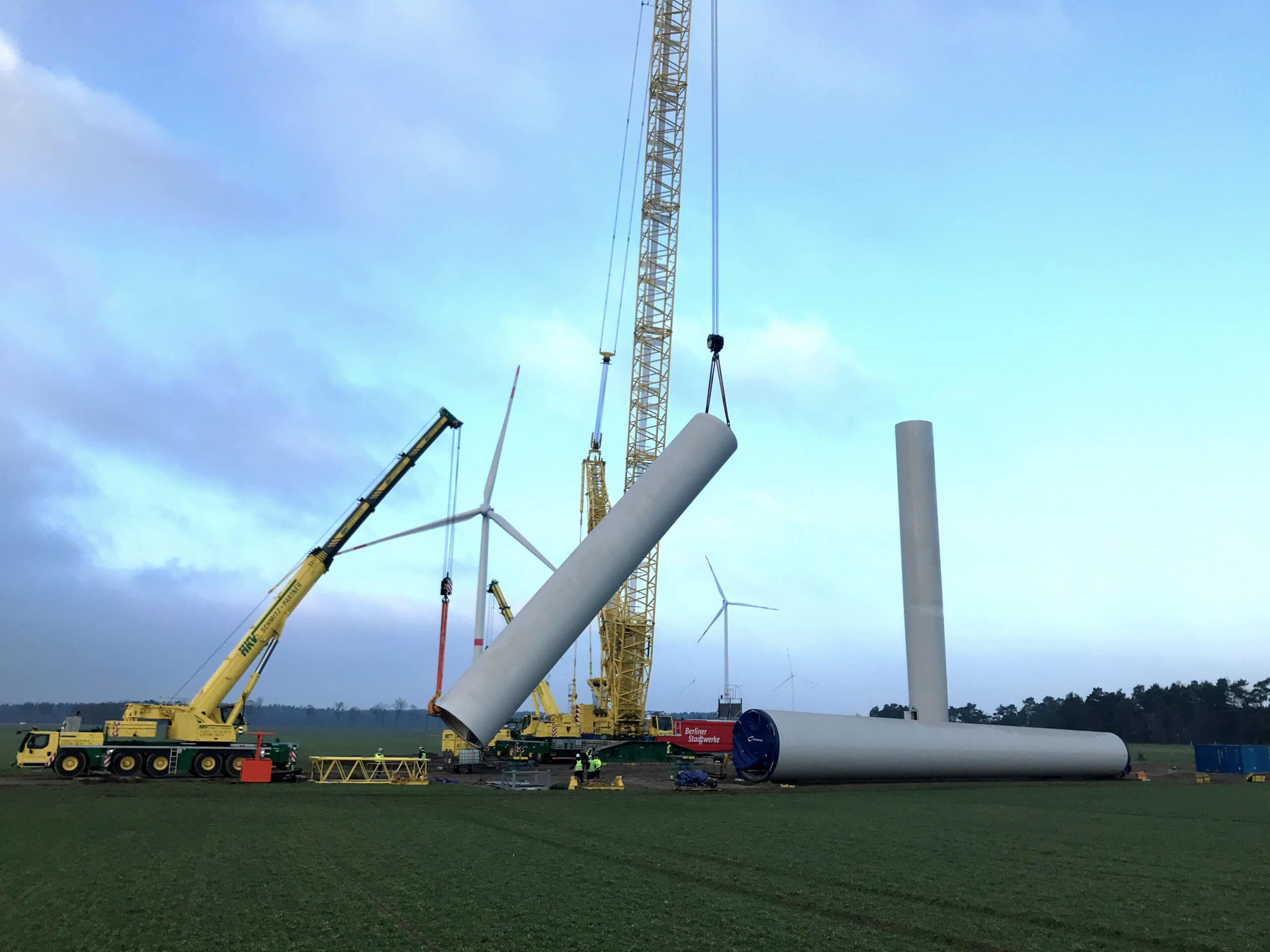 Kran hebt Turm einer Windenergieanlage