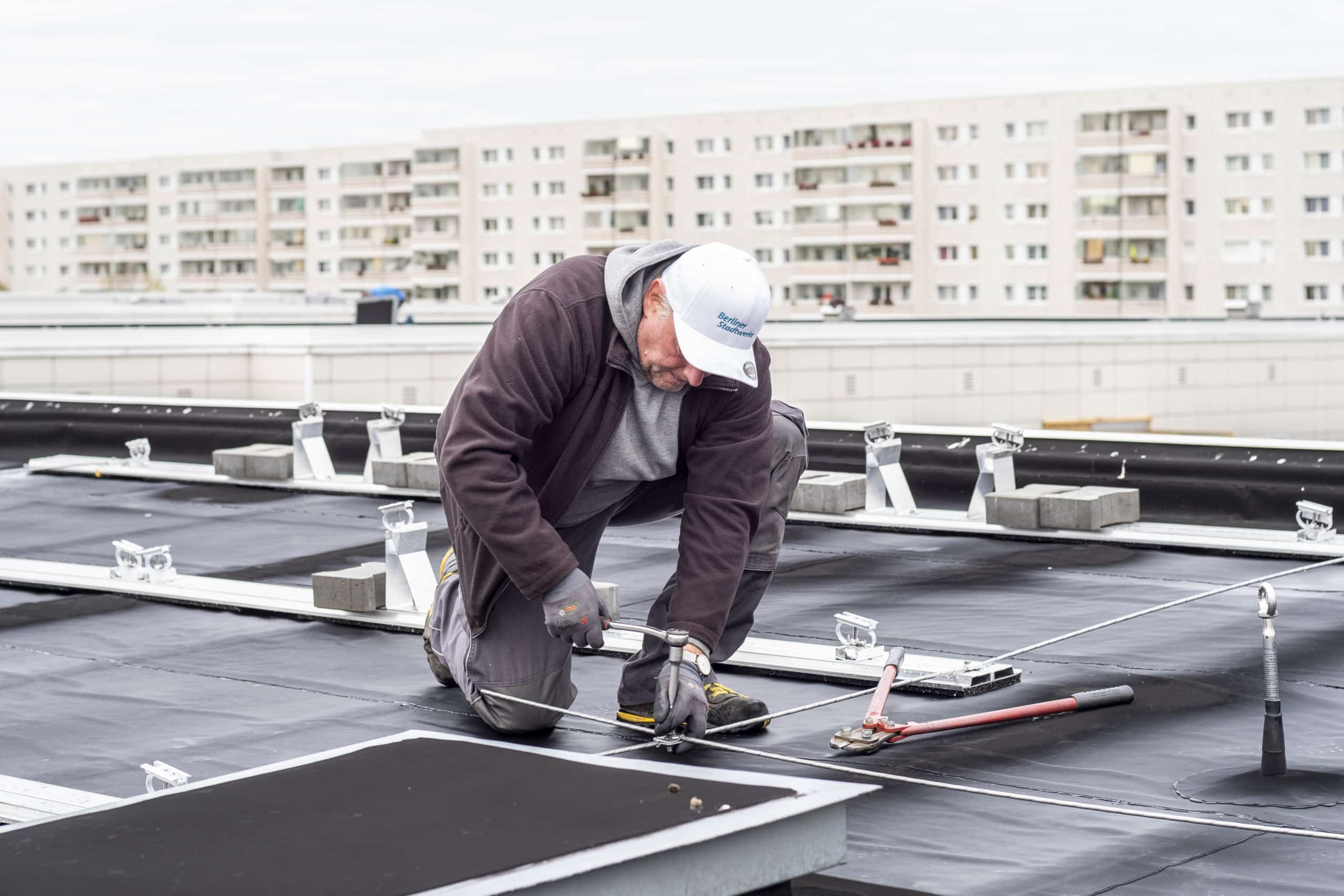 Ein Mann montiert Solarmodule auf einem Dach