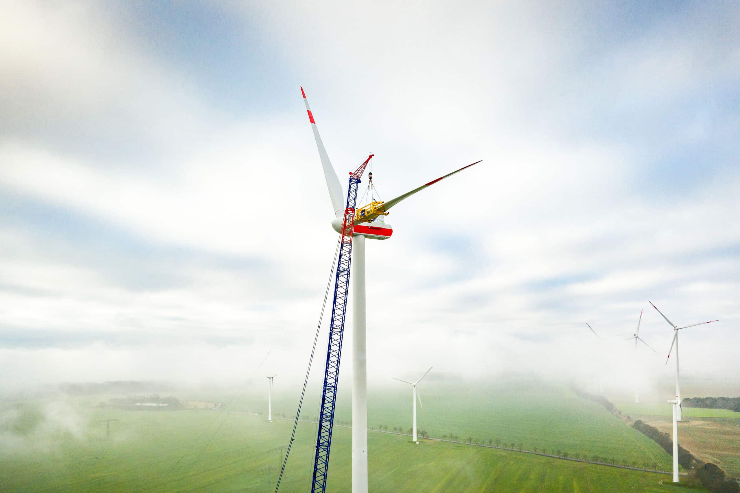 Ein Kran montiert die Rotorblätter einer Windenergieanlage der Berliner Stadtwerke