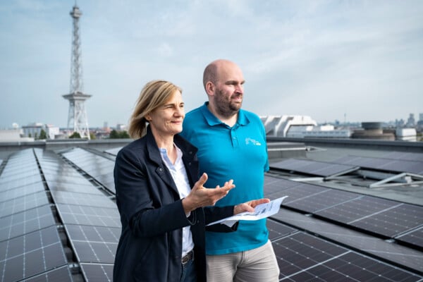 Stadtwerke-Geschäftsführerin Dr.-Ing. Kerstin Busch und Projektleiter Tino Hain auf dem Hallendach der Messe Berlin mit Solaranlage