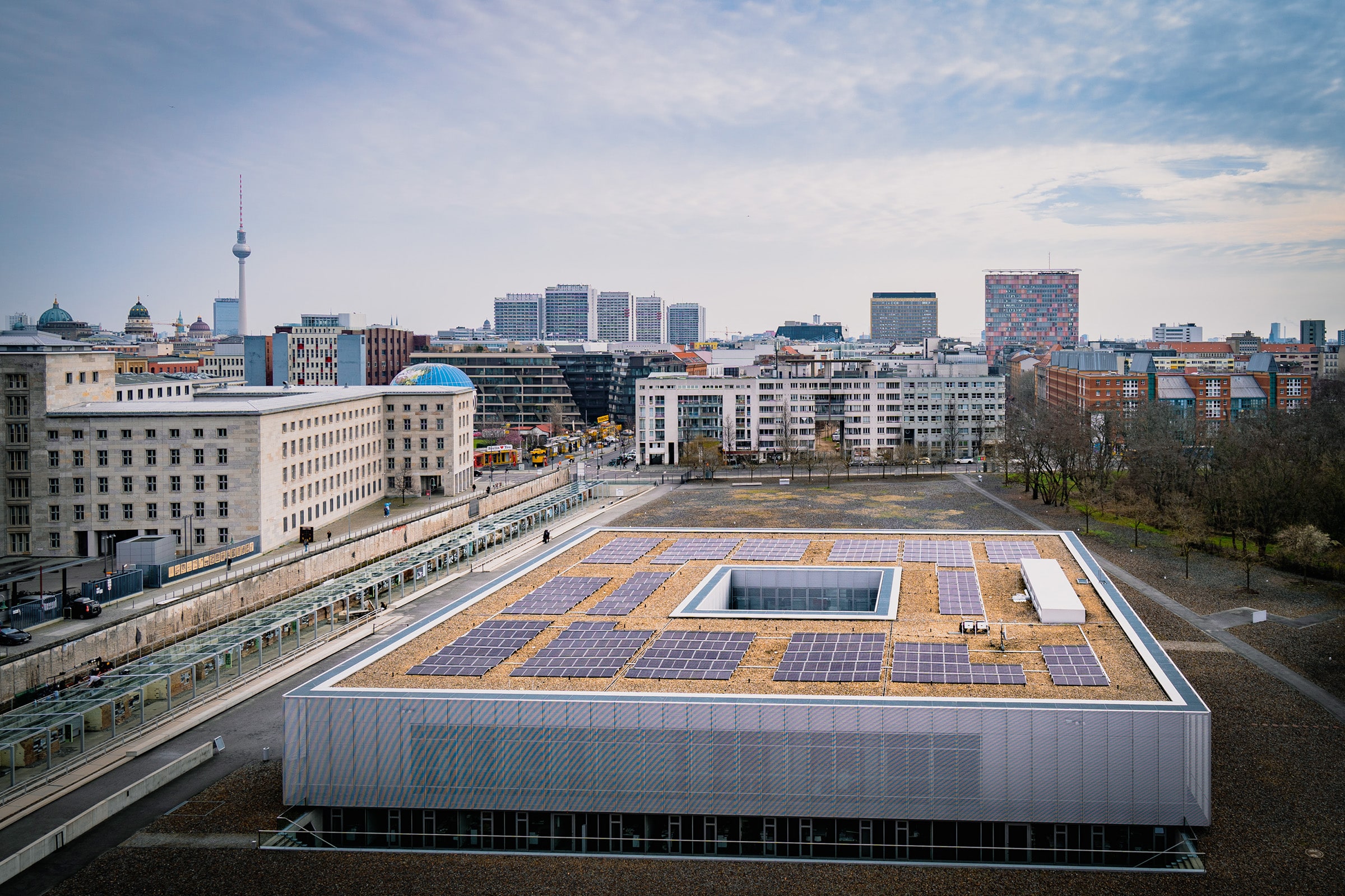 Solaranlage der Berliner Stadtwerke auf dem Dach der Topographie des Terrors aus der Vogelperspektive mit Berliner Fernsehturm im Hintergrund