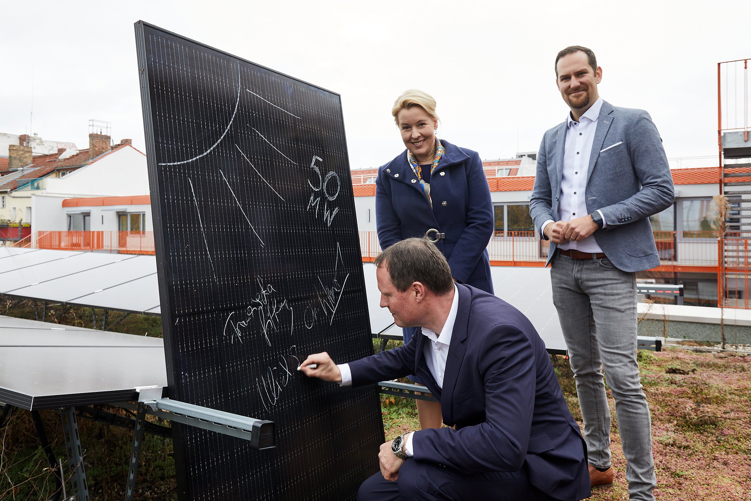 Ulrich Schiller, Geschäftsführer der HOWOGE Wohnungsbaugesellschaft mbH, unterzeichnet ne-ben Energiesenatorin Franziska Giffey und Stadtwerke-Geschäftsführer Chris Werner die Rah-menvereinbarung zur Errichtung von 50 MW Solarleistung symbolisch auf einem Solarmodul.