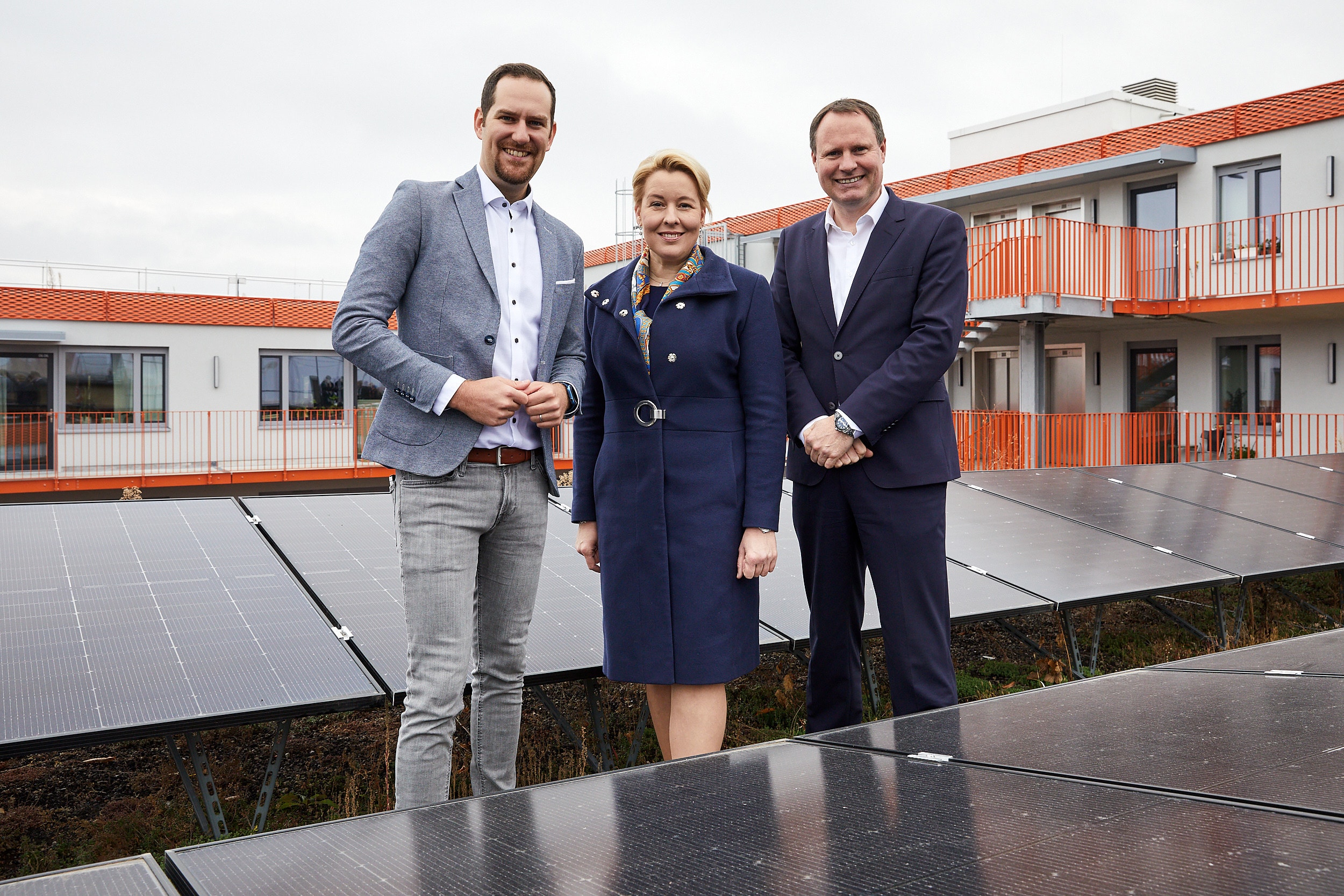 Stadtwerke-Geschäftsführer Chris Werner, Energiesenatorin Franziska Giffey und HOWOGE-Geschäftsführer Ulrich Schiller auf dem Dach des Campus´ Ohlauer Straße vor einer Solaranalge.