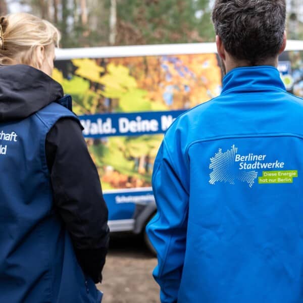 Dr. Sabine Buder, Geschäftsführerin der Schutzgemeinschaft Deutscher Wald Landesverband Brandenburg e. V., und ein Mitarbeiter der Berliner Stadtwerke im Stadtwerke-Wald – fotografiert von hinten